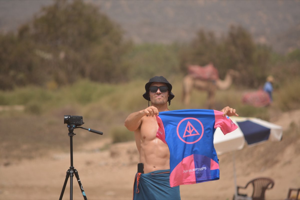 AP Surftrips coach holding up the camp lycra next to a camera on a tripod