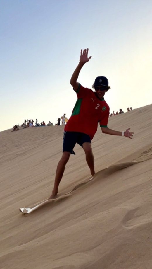Sandboarding down a dune