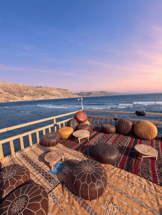 Terrace with Moroccan poufs at sunset in Imsouane
