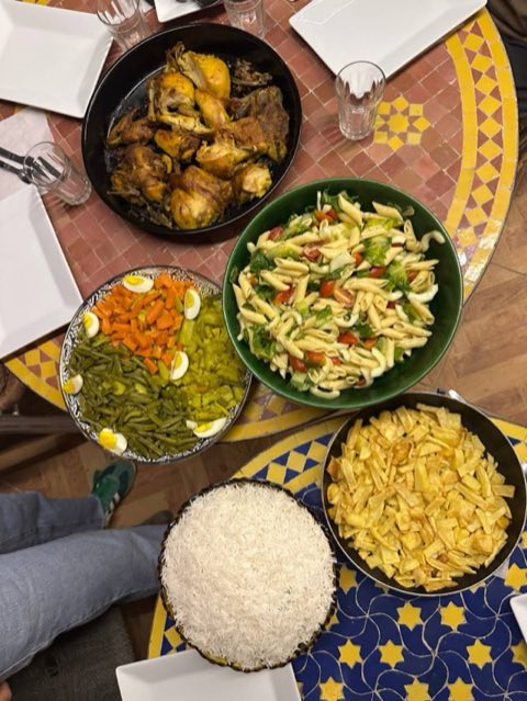 Family-style dinner with chicken, salads, rice and fries