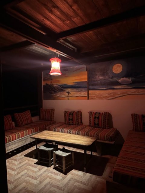 Lounge with surf murals and a lantern at night