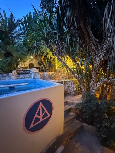 Villa pool at dusk with the AP Surftrips logo